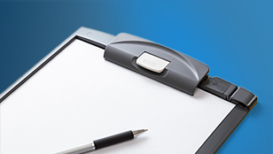 Un primo piano di una cartellina portadocumenti con un foglio bianco per annotare informazioni. Sopra si trova una penna per scrivere. Gli oggetti sono su uno sfondo blu scuro uniforme.