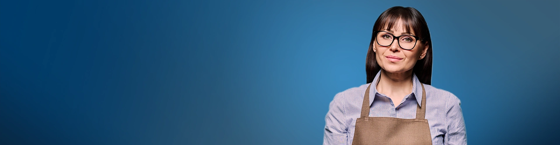 Su fondo blu sfumato con sulla destra una donna a mezzo busto con capelli scuri e occhiali, che indossa una camicia azzurra e un grembiule da lavoro marrone, mentre guarda direttamente l'osservatore con un sorriso accennato.