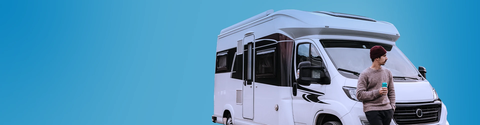 Uomo appoggiato ad un camper con in mano una bibita in lattina