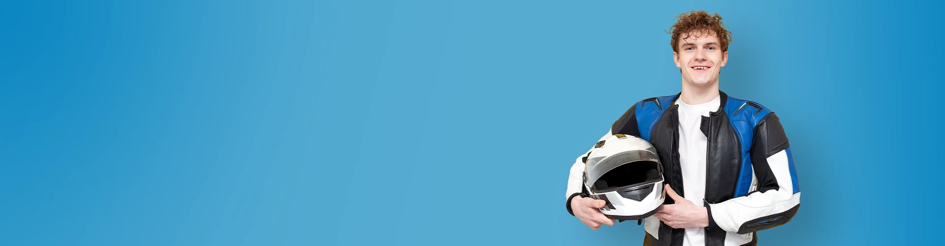 Ragazzo sorridente con in mano un casco da motociclista