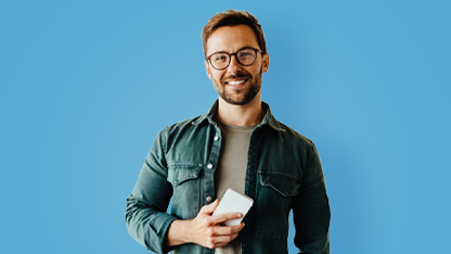 Giovane uomo sorridente con in mano uno smartphone