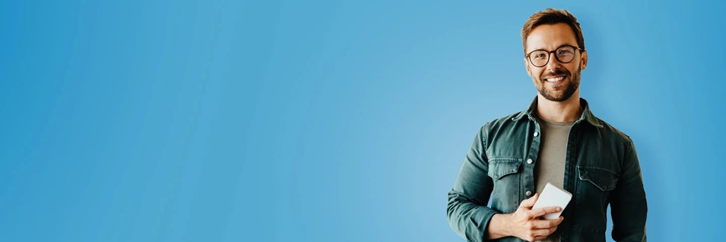 Giovane uomo sorridente con in mano uno smartphone