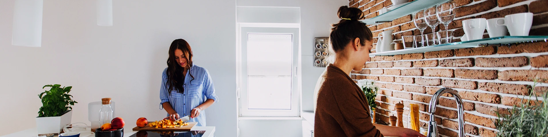 Giovane donna con capelli raccolti davanti al lavandino della cucina